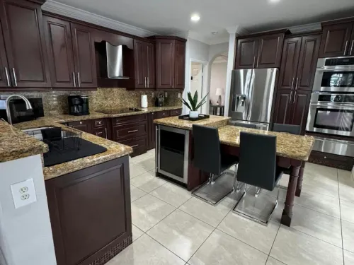 Spotless dark wood kitchen with granite countertops and stainless appliances after cleaning