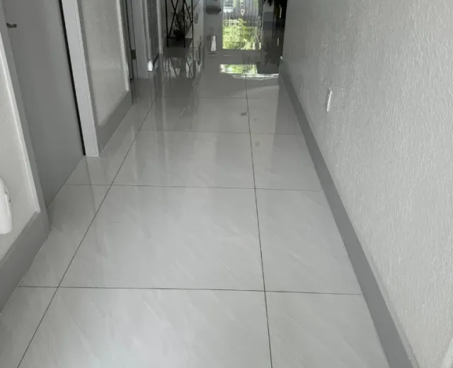 Mirror-polished tile hallway floor maintained through an Ire Cleaning Services recurring cleaning plan