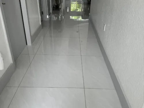 Mirror-polished tile hallway floor after cleaning