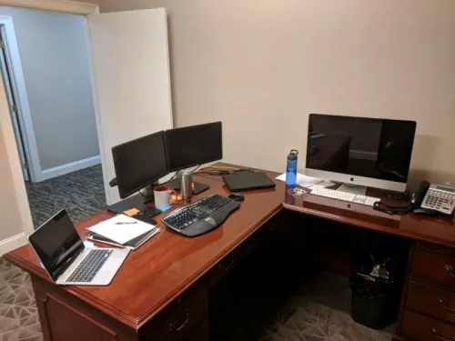 Dusted and organized office desk with monitors after a commercial clean