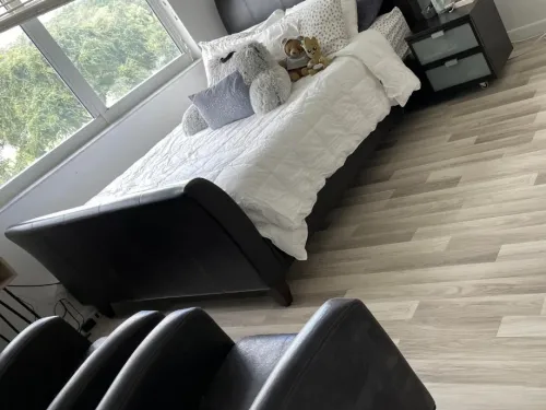 Freshly made bedroom with wood-look flooring after a house cleaning
