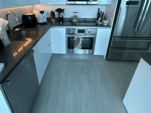 Modern high-rise condo kitchen with white cabinetry and stainless appliances after cleaning